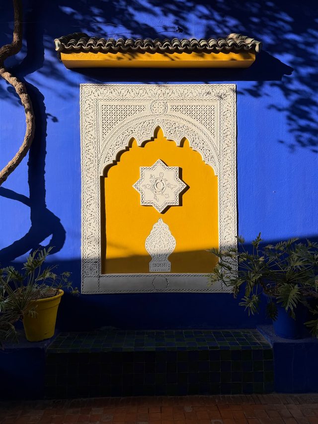 Majorelle blue wall with carved Moroccan plasterwork at Jardin Majorelle, Marrakech.