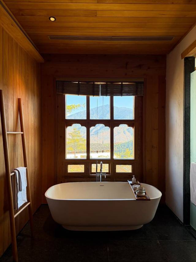 Freestanding bathtub at Six Senses Thimphu framed by an arched window onto the Himalayas, Bhutan. Freestanding bathtub at Six Senses Thimphu framed by an arched window onto the Himalayas, Bhutan.
