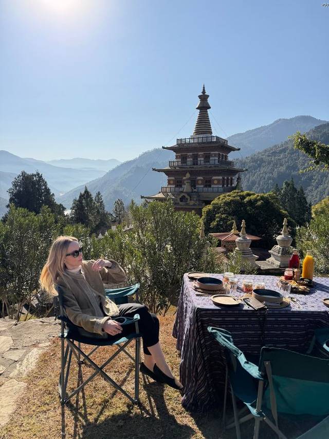 Luxury private outdoor breakfast in Bhutan, set beside a chorten with Himalayan ridgelines behind.