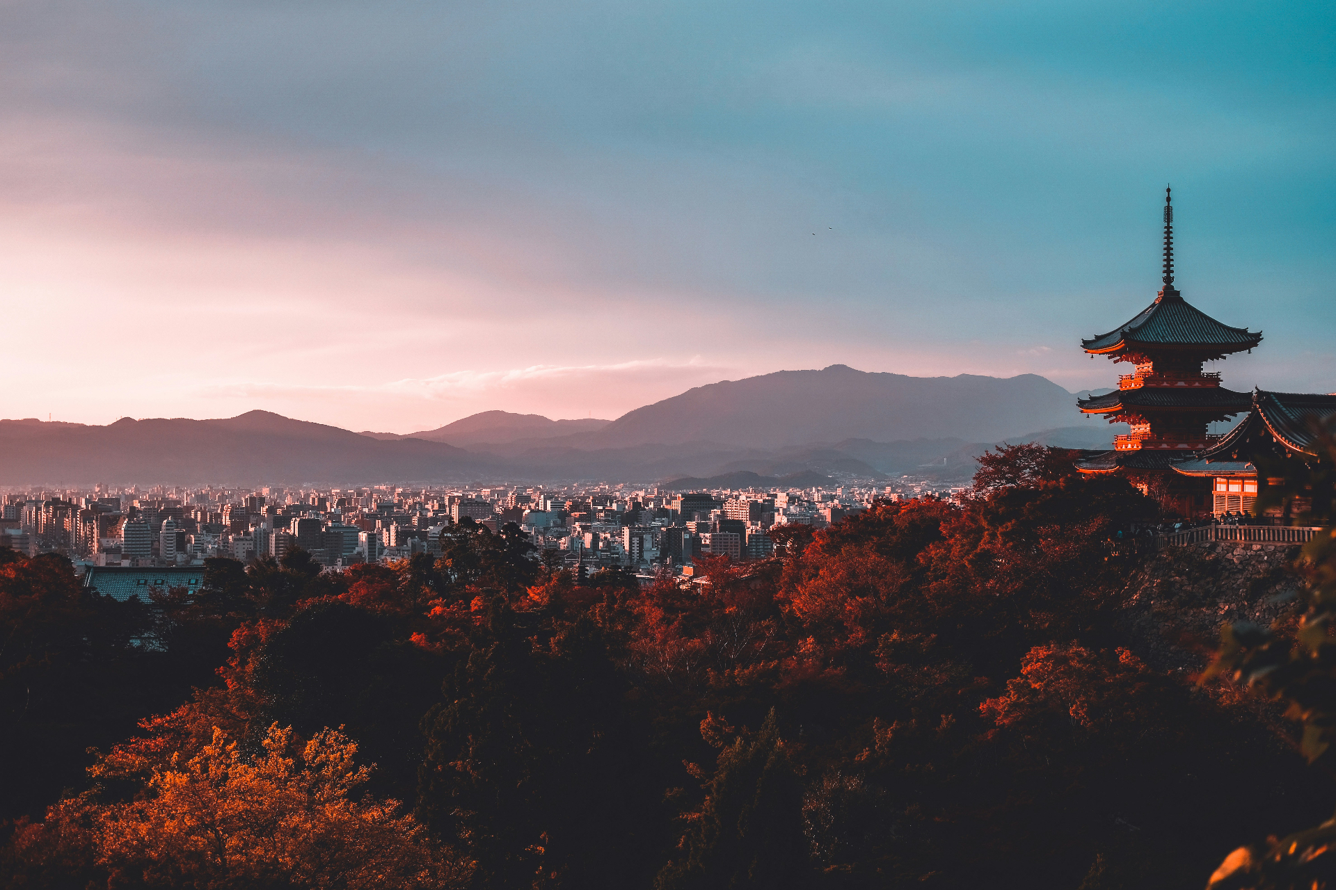 Kyoto-style pagoda overlooking the Tokyo cityscape at sunset.