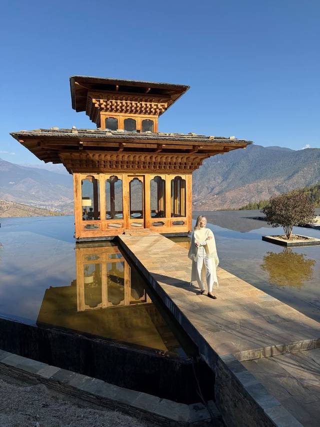 Guest on the stone causeway to the pavilion at Six Senses Thimphu, overlooking the Thimphu valley, Bhutan. Guest on the stone causeway to the pavilion at Six Senses Thimphu, overlooking the Thimphu valley, Bhutan.