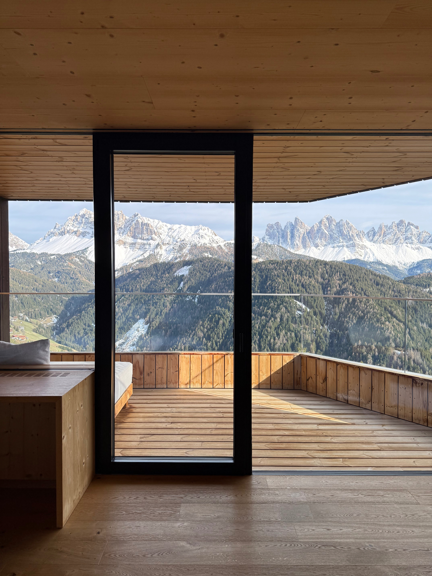 Panoramic Dolomites view through the wooden terrace of a Forestis suite.