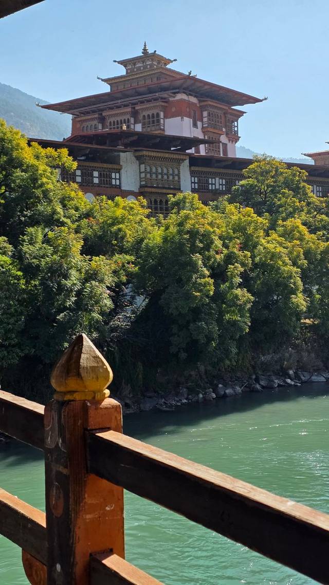 Punakha Dzong seen from the traditional wooden bridge over the turquoise Mo Chhu river, Bhutan.