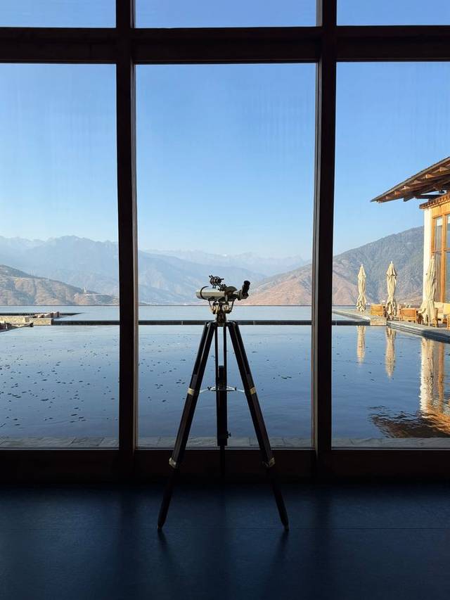 Brass telescope facing floor-to-ceiling mountain windows in a suite at Six Senses Thimphu, Bhutan. Brass telescope facing floor-to-ceiling mountain windows in a suite at Six Senses Thimphu, Bhutan.