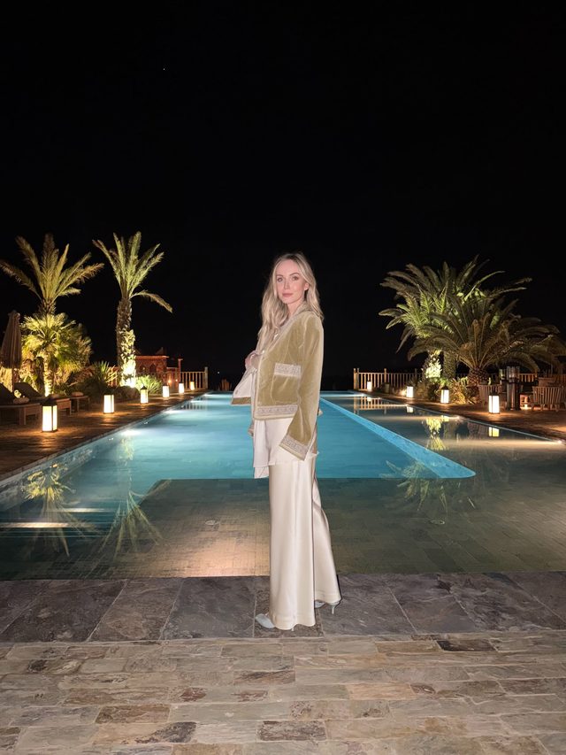 Luxury travel advisor Eva Szoradi by a lantern-lit pool at a kasbah hotel in the Agafay Desert, Marrakech.